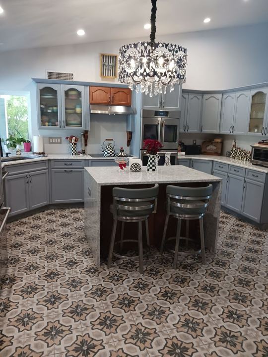 Kitchen with painted cabinets, glass-front uppers, and a waterfall island