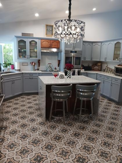 Kitchen with painted cabinets, glass-front uppers, and a waterfall island
