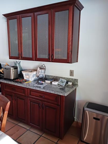 Cherry buffet base cabinets with granite top and glass-front wall cabinets
