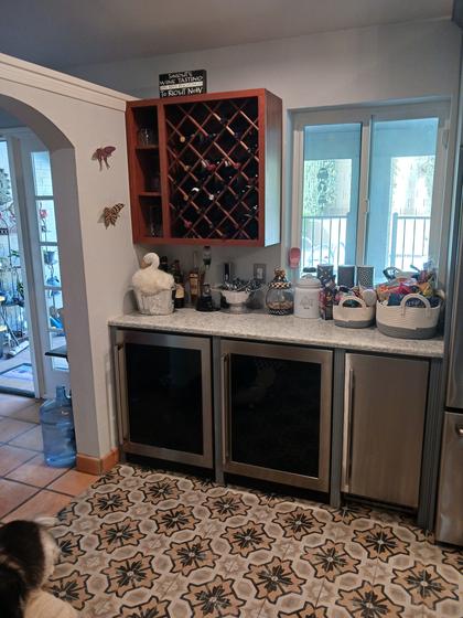 Wine bar with a cherry lattice wine rack above built-in beverage coolers