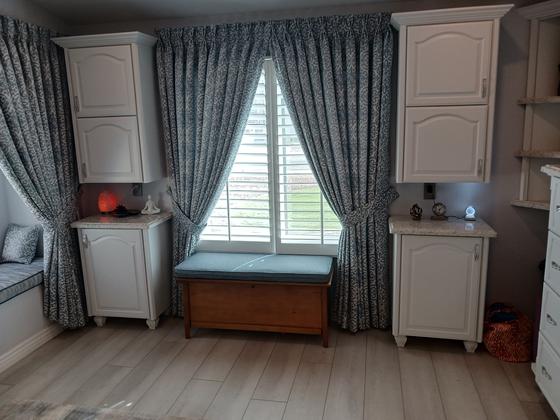 Window seat flanked by white built-in cabinets