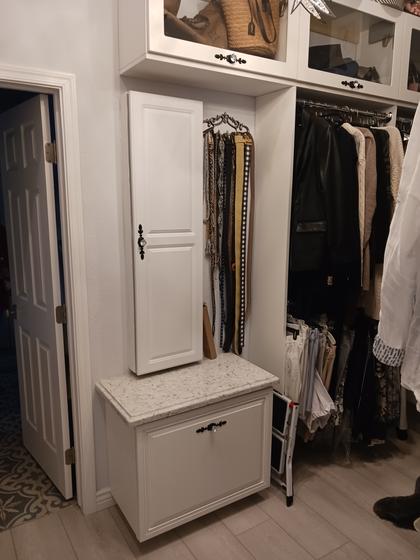 Walk-in closet built-ins with a stone-topped cabinet and display uppers