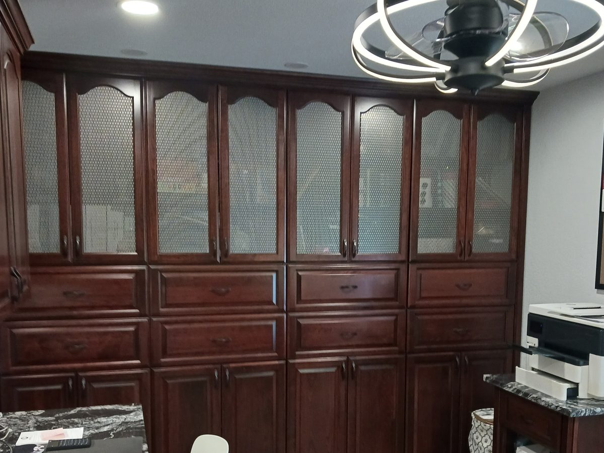 Floor-to-ceiling cherry office cabinetry with glass-front uppers