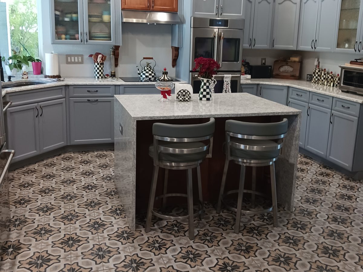 Remodeled kitchen with painted gray cabinets and a stone waterfall island