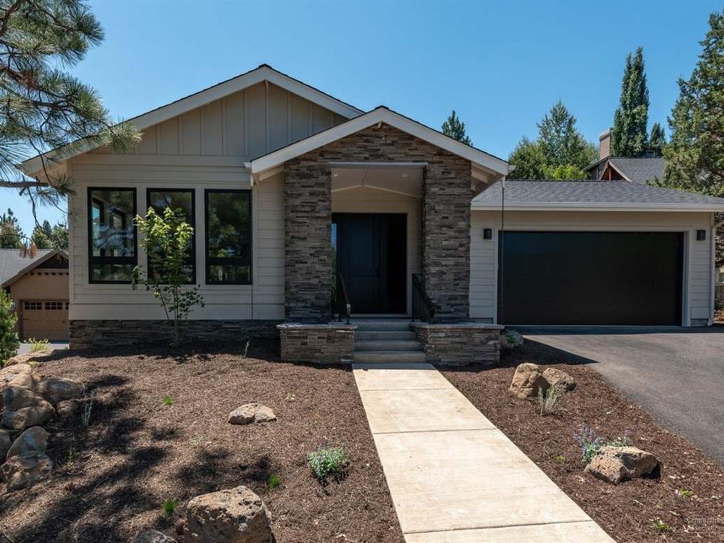 Single-story new home with a stone-veneer entry and two-car garage