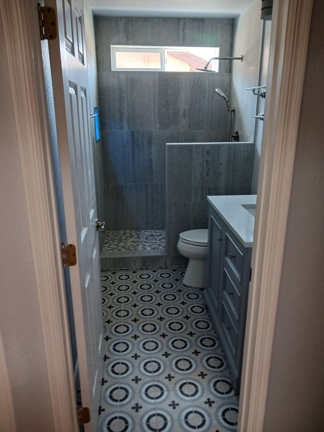 Guest bathroom with patterned cement-look floor tile and a walk-in shower