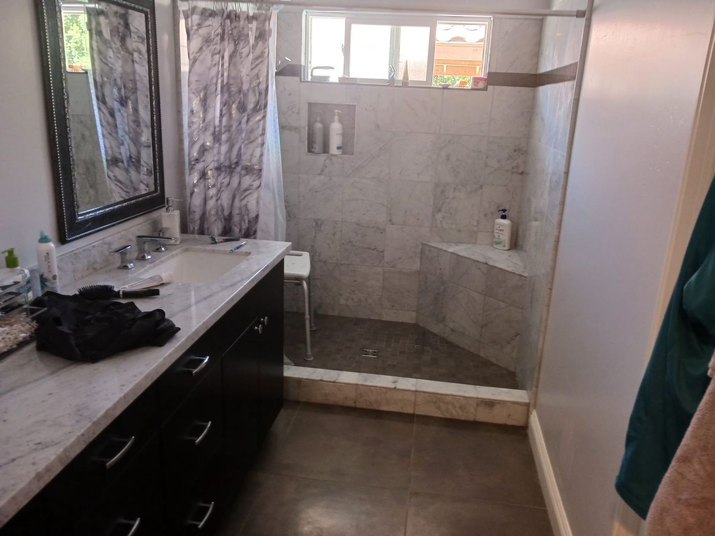 Primary bathroom with marble walk-in shower and built-in corner bench